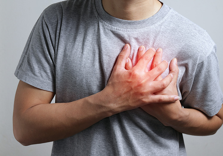 A person is shown with a hand on their chest, holding a heart-shaped object, possibly symbolizing health or love, against their chest, which appears to be glowing red, suggesting an emphasis on the heart.